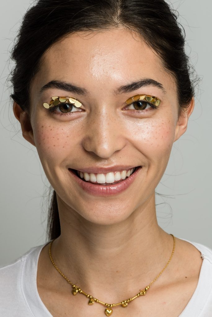 Beauty portrait with gold eye makeup and a natural smile